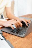 Hands typing on a laptop in a modern workspace. Focus on fingers and keyboard. photo