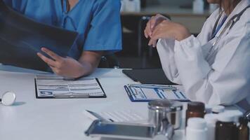 Two doctors talking at a table with a patient video
