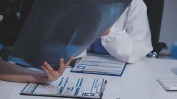 A doctor is looking at a x - ray on a clipboard video