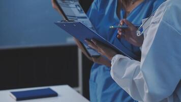 Two doctors are holding a clipboard and looking at something video