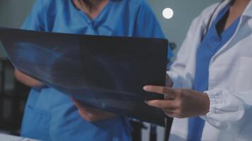 Two doctors are looking at an x - ray video