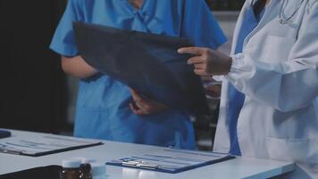 Two doctors are looking at a paper on a table video