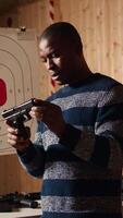 Vertical Shooting range safety officer ensuring clients are following regulations and operating firearms safely. African american firing range gallery worker giving instructions to customers, camera A video