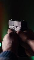 Vertical Shooting gallery client using handgun to hit paper targets with ammo. Close up shot of person wearing safety gear at indoor firing range facility shooting bullseyes, enjoying using weapons, camera B video