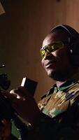 Vertical Portrait of cheerful soldier doing training in shooting range, reloading rifle. Joyous military unit in firing range practicing with semiautomatic weapons, wearing protective equipment, camera B video