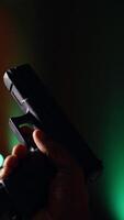 Vertical Man reloading handgun in indoor shooting range, following safety protocols. Person carefully handling weapon following methodical firearms practice safety rules, camera B close up video