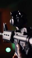 vertical hombre sostiene asalto rifle, disfrutando recreativo disparo experiencia en disparo rango. persona practicas con semiautomático arma en seguro ambiente a disparo rango compañía, cámara si extremo cerca arriba video