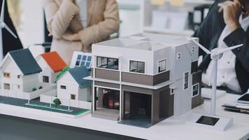 A model of a house with people standing around it video