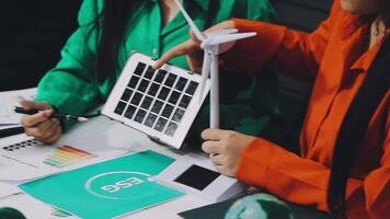 Two people working on a laptop with a solar panel video