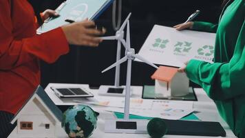 Two people are holding a paper with wind turbines on it video
