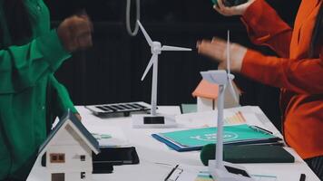 Two people standing around a table with wind turbines video