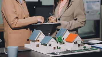 Two women are looking at a model of a house video