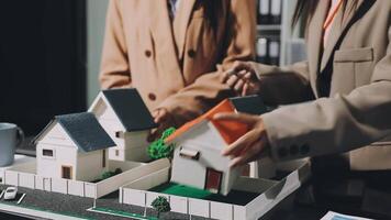 Two people looking at model houses on a table video
