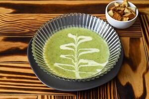 Broccoli Soup on the wooden table with crackers side view photo
