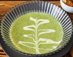 Broccoli Soup on a wooden table with crackers side view photo