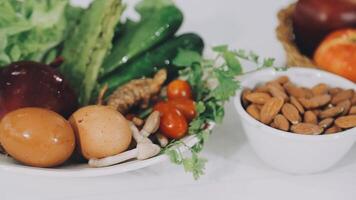 A bowl of fruits and vegetables with nuts and apples video