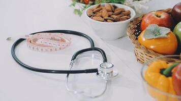 A stethoscope is sitting next to a basket of fruits and vegetables video