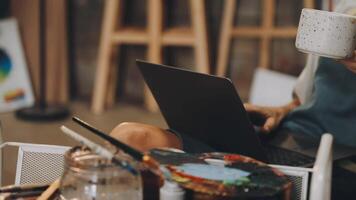 A woman is sitting at a table with a laptop and a cup of coffee video
