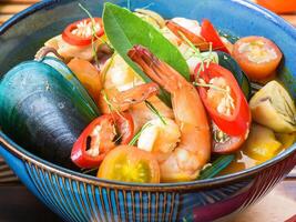 Soup tom yum with tomato and mussels side views photo