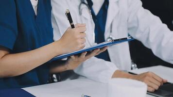 Two doctors are writing on a clipboard video