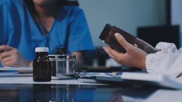 A doctor is using a cell phone while another person looks at it video