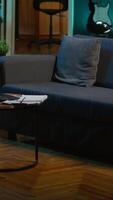Vertical Stylish modern apartment decorated with cool furniture and neon lights, home theatre and setup with big tv for a young adult. Empty loft illuminated and equipped with electronics, comfortable space. video