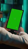 Vertical Confident tech user looking at isolated mockup display in his living room, relaxing with his remote job on the couch. African american happy adult browses the internet. Camera A. video