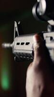 vertical hombre sostiene asalto rifle, disfrutando recreativo disparo experiencia en disparo rango. persona practicas con semiautomático arma en seguro ambiente a disparo rango compañía, cámara un extremo cerca arriba video