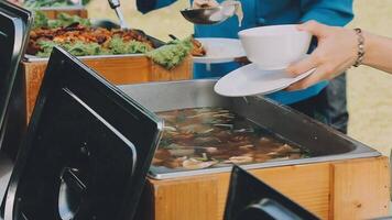 A person serving food from a buffet table video