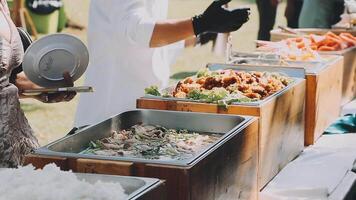 A buffet table with food and people standing around it video