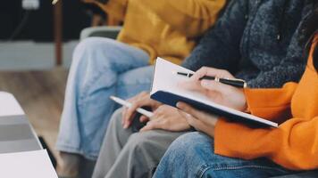 People sitting in a row with notebooks and pens video