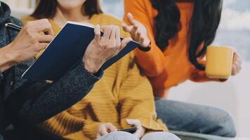 Three people sitting on a couch with a notebook video