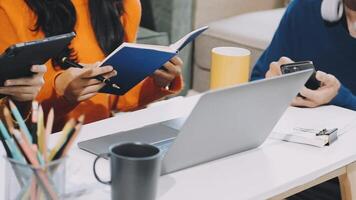 Three people sitting at a table with laptops and notebooks video