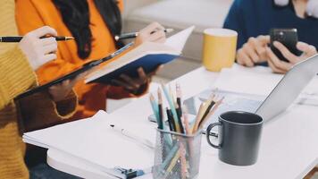 People sitting at a table with notebooks and pens video