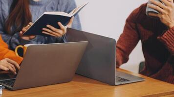 Three people sitting at a table with laptops video