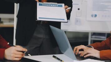 A man is holding a contract in front of two people video