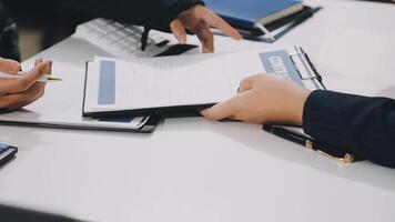 Two people are sitting at a table with papers and pens video
