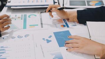 Business people working on a table with graphs and papers video