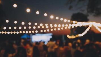 A crowd of people at an outdoor event with string lights video