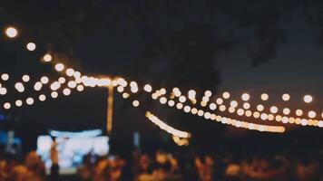 A group of people at an outdoor event with string lights video