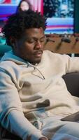 Vertical Young black person overseeing schedule and planning activities at his home, working on time management with online tools. Male adult utilizing a calendar on pc and checking the planner. Camera A. video