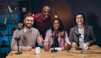 Podcasters giving thumbs up during recording session, displaying collaborative energy in sleek professional studio setting photo