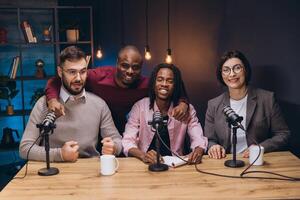 Four podcasters are recording a new episode in a professional studio, discussing and sharing their insights with microphones and equipment photo