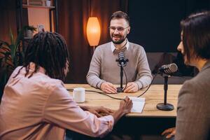 Diverse podcasters recording audio content in a home studio, using microphones and notepad photo