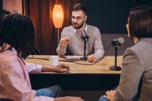 Podcast host interviewing two guests in a professional recording studio, discussing interesting topics for their audience photo