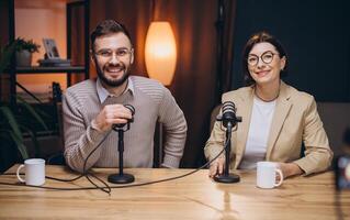 Two smiling podcasters engaging in lively conversation while recording audio content in a professional studio setting photo