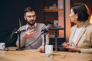Professional podcasters recording audio using studio microphones within dynamic radio station workspace photo