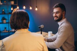 Podcasters discussing content near professional microphones, capturing audio in soundproofed studio with recording gear surrounding them photo