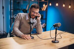 Energetic podcaster speaking into microphone during recording session, capturing professional audio content in sleek home studio environment photo