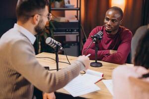 Radio hosts collaborating with guest during podcast recording, engaging in lively conversation photo